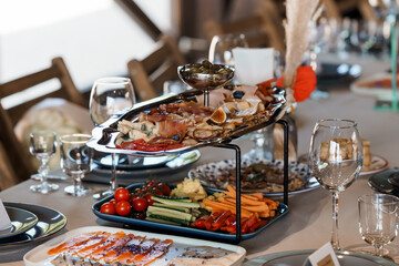 Elegant Wedding Charcuterie Board Presentation with Salmon, Cheese, and Fresh Vegetables on a Tiered Stand, Rustic Table Setting.