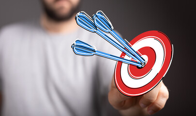 Concept of business strategy, success, and achieving goals. Hand holding a target with arrows in...