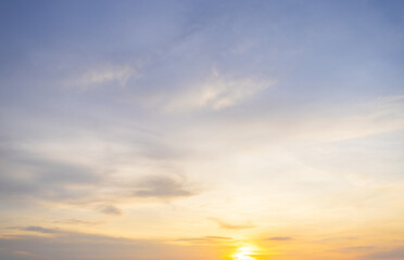 The background is full of orange light at sunset and sunrise,A breathtaking sky painted with shades of orange, peach, and blue during sunset, featuring soft, sweeping cloud formations.