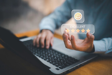 Businessman using smartphone to give five-star positive review with smiley face icon, Customers give 5-star reviews,symbolizing excellent customer feedback, and user satisfaction in digital service.