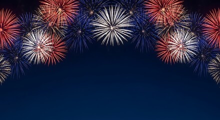Vibrant red white and blue fireworks bursting in a dark night sky
