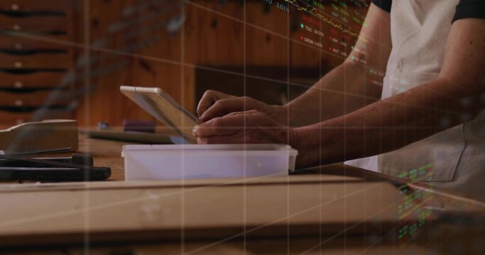 Reviewing craftsperson wearing apron exploring plan on tablet at craft studio, with workbench