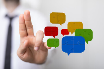 Hand reaching towards speech bubbles with puzzle elements. Symbolizing communication, connection,...