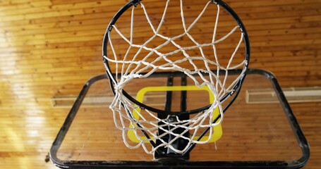 Hanging basketball hoop with white net inside gym, with yellow padding, black support frame © vectorfusionart