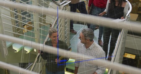 Six professionals ascending metal glass staircase in office atrium, with laptops and document tubes