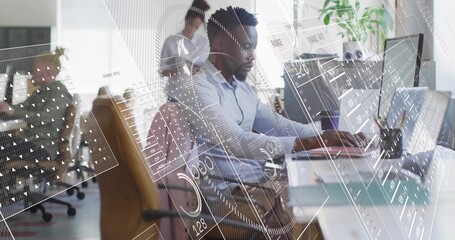 Typing male professional wearing collared shirt at open-plan office with laptop and data overlays