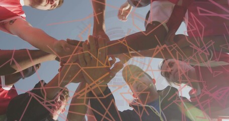 Holding up hands athletes forming huddle on field, with red jerseys, shorts, dark jacket