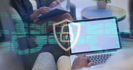 Typing man analyzing scrolling code overlay in office lounge, with laptop and printed documents