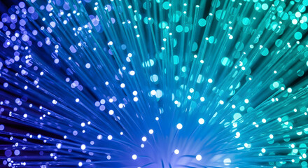 A vibrant display of fiber optic cables with glowing ends in shades of blue and green light