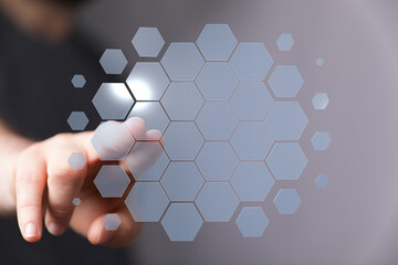 Abstract image of finger interacting with digital hexagon interface. Futuristic technology concept.