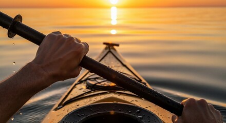 Person kayaking on a calm lake at sunset. First-person view of hands holding a paddle with a golden sun reflection on the water. Outdoor adventure and recreation concept