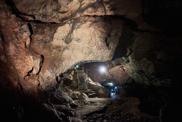 Vadu Crisului Cave in Bihor, Romania, features impressive limestone formations. Stalactites hang from the ceiling, while stalagmites rise from the floor, some meeting to form columns