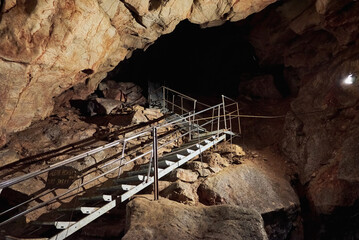 Vadu Crisului Cave in Bihor, Romania, features impressive limestone formations. Stalactites hang from the ceiling, while stalagmites rise from the floor, some meeting to form columns