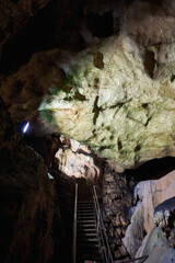 Vadu Crisului Cave in Bihor, Romania, features impressive limestone formations. Stalactites hang from the ceiling, while stalagmites rise from the floor, some meeting to form columns