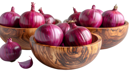 Close-up of red onions in wooden bowls, with a clove beside