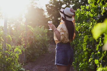 Naklejka premium Happy beautiful Smiling woman walking at wineyard with a Glass of Red wine.Wine tourism at Tuscany,Italy