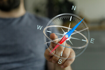 A person holding a compass guides towards the right direction, planning a journey of exploring the world and decision making concept. © vegefox.com