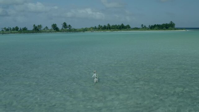 Stunning 4K aerial footage of two fly fishermen wading across the shallow turquoise flats of Kiritimati (Christmas Island), Kiribati. Crystal-clear water, expansive coral flats, and the remote tropica