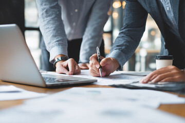 Businessman or an accountant team are analyzing data charts, graphs, and a dashboard on a laptop screen in order to prepare a statistical report and discuss financial data in office. Data analysis
