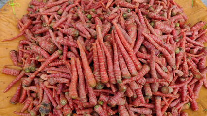 Pile of fresh red carrots arranged for sale at local vegetable market showing organic farming and healthy lifestyle