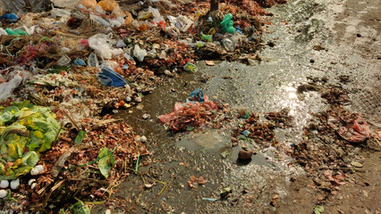 Pile of vegetable waste dirty leaves, and mud on the ground in a local market showing pollution and poor hygiene