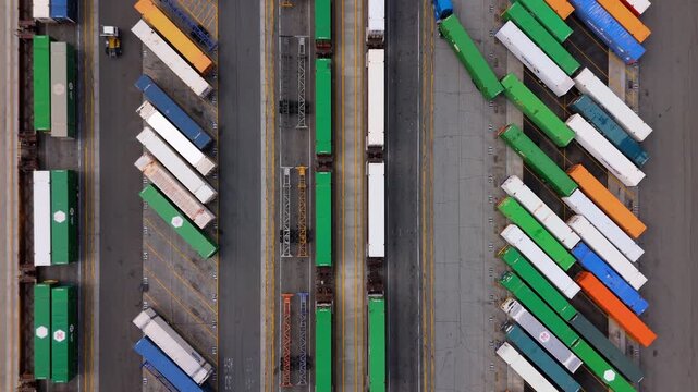 Aerial top-down view of cargo trucks and trains at intermodal terminal in October 7, 2025