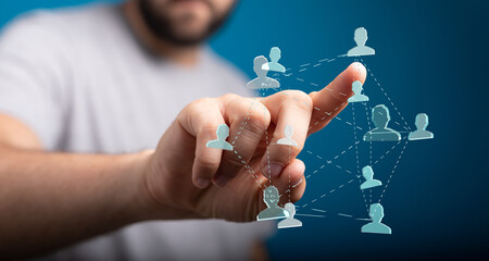 Close-up of a person's hand interacting with a network of connected human figures. Symbolizing...