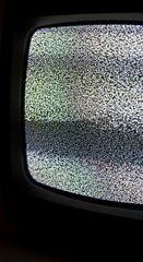 Close-up view of a vintage television screen displaying static, showcasing a grainy, pixelated texture with muted tones and horizontal lines.