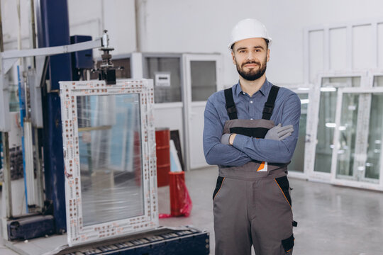 Factory worker posing with arms crossed in pvc windows and doors production line
