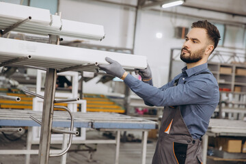 Factory worker checking pvc window and door frames