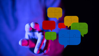 Abstract image featuring a hand reaching towards colorful puzzle-shaped speech bubbles, symbolizing communication, teamwork, and ideas. Perfect