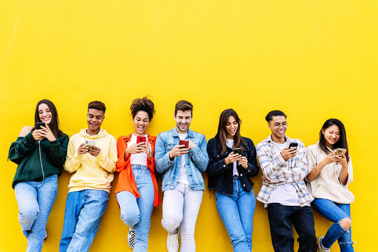 Multiracial young friends having fun sharing media content on mobile phone. Communication and social media concept - Powered by Adobe