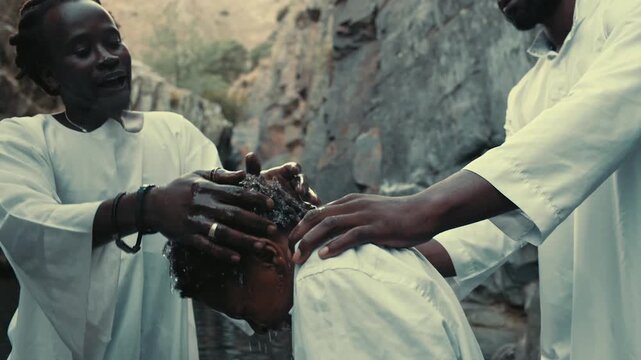Baptism ceremony with participants in white gown robes at river location