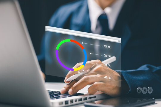 A businessman using a laptop with a holographic circular graph showing percentages, symbolizing digital financial dashboard, analytics, and smart business technology.