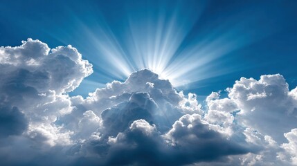 Sunlight breaking through clouds in a vibrant blue sky.