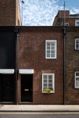 Charming brick houses line a quiet street in an urban neighborhood showcasing modern architecture and thoughtful design in the heart of the city during a sunny day
