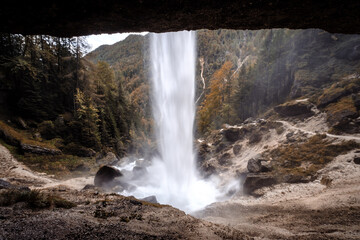 Obraz premium View of a waterfall from a cave entrance.
