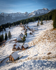 Snow-covered village nestled in the mountains under a clear sky.