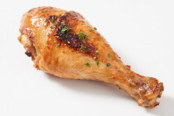 Delicious golden brown roasted chicken leg with crispy skin and fresh herbs, placed naturally on a pure white background, highlighting its juicy texture and rich, appetizing caramelized color.