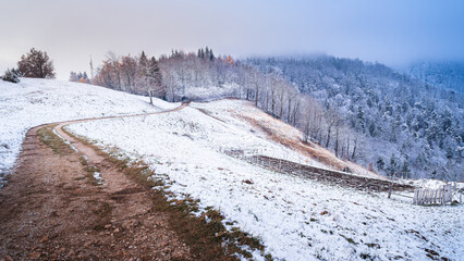 Snow sprinkled hill at sunset