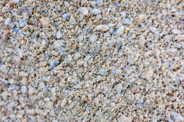 Close up texture of fine light sand with small stones and grains, natural neutral background, macro shot of dry sandy surface, beach or construction material pattern, summer and autumn concept