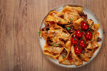 pappardelle pasta with bolognese sauce, topped with parmesan cheese and cherry branch, homemade, no people,