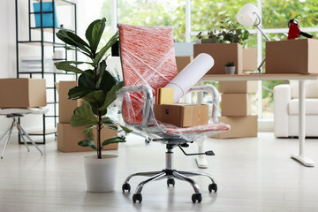 Many moving boxes, houseplants and furniture in new office