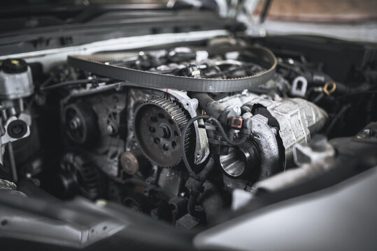 Intricate details of a car engine are captured in a close-up, showing its inner workings. - Powered by Adobe