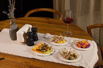 An Elegant Dining Setup Featuring an Array of Assorted Dishes Accompanied by Fine Red Wine