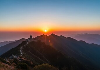 Obraz premium Sunrise over a mountain range with ancient temples and a winding path, clear sky with orange hues