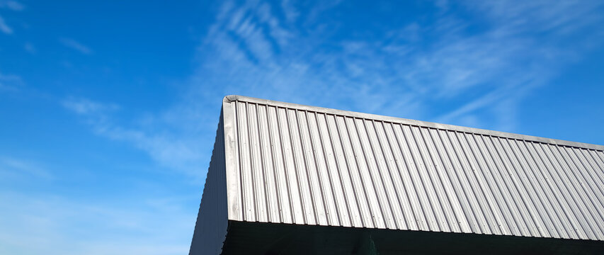 Metal sheet roof curve on blue sky. Modern construction, Metal ribbed arch span roof covering, Large building  roof