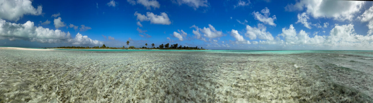 Crystal-clear turquoise waters lap onto a pristine white sand shoreline on Kiritimati (Christmas Island), Kiribati. This remote Pacific coral atoll is renowned for its untouched lagoons, world-class s