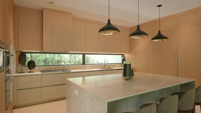 Modern kitchen with tall light wood cabinets and long horizontal window above the counter. Countertop and island are made of light stone with built in stovetop on the left
