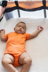 Cute baby sleeping soundly in playard crib